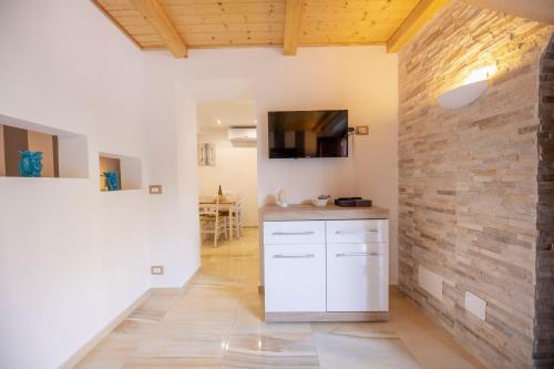 a kitchen with white cabinets and a brick wall at Donna Flavia - Casa Vacanze centro storico Palermo in Palermo