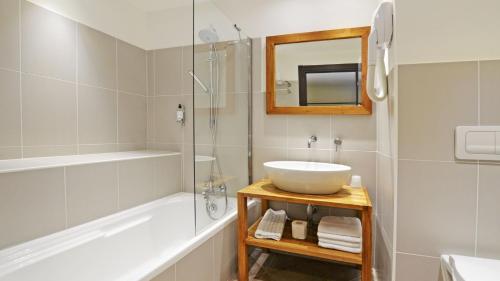 a bathroom with a sink and a shower and a tub at La Florentine in Saint-Florent