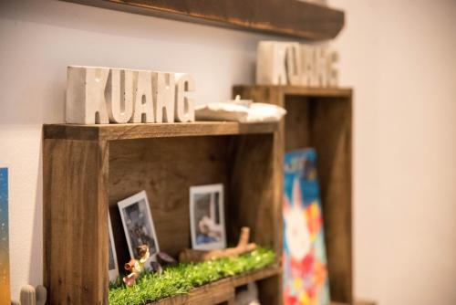 two wooden shelves with dolls and pictures on them at 框框背包客棧 Kuang Kuang Hostel in Longjing