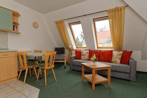 a living room with a couch and a table and chairs at Pension Am Kirschberg in Bannewitz