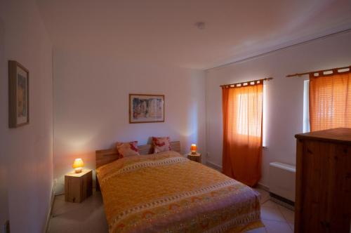 ein Schlafzimmer mit einem Bett mit zwei Lampen und zwei Fenstern in der Unterkunft Ferienwohnung Sonnenblume Himmelpfort in Pian