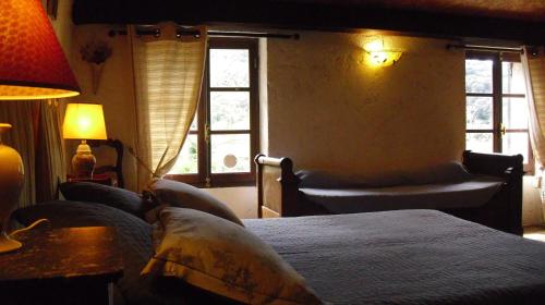 a bedroom with a bed and two chairs and windows at Maison d'Hôtes de Charme de Croccano in Sartène