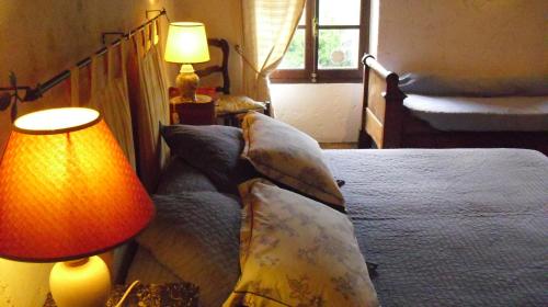 a bedroom with a bed with pillows and two lamps at Maison d'Hôtes de Charme de Croccano in Sartène