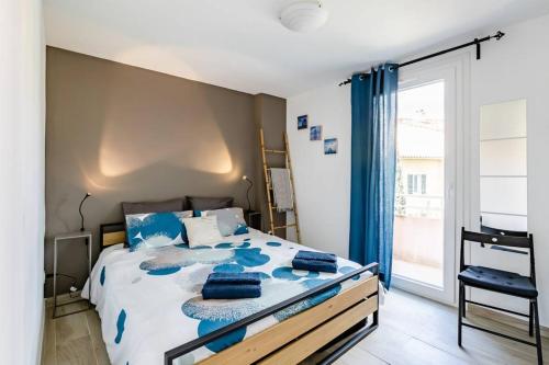 une chambre avec un lit avec des draps bleus et une fenêtre dans l'établissement La Cassidaine, à Cassis