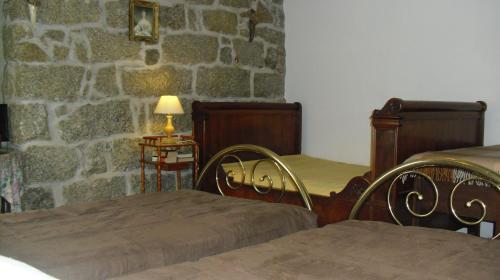 a bedroom with two beds and a stone wall at Maison d'Hôtes de Charme de Croccano in Sartène