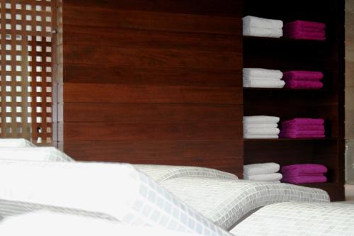 a bedroom with a bed with white sheets and towels at Hotel Convento Aracena & SPA in Aracena