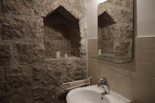 a bathroom with a sink and a stone wall at Al Libro Letto in Viterbo