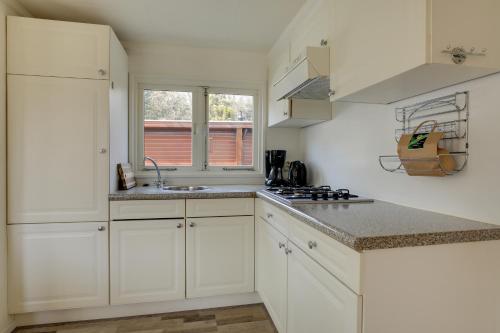 a white kitchen with white cabinets and a sink at Bungalowpark Het Verscholen Dorp in Harderwijk