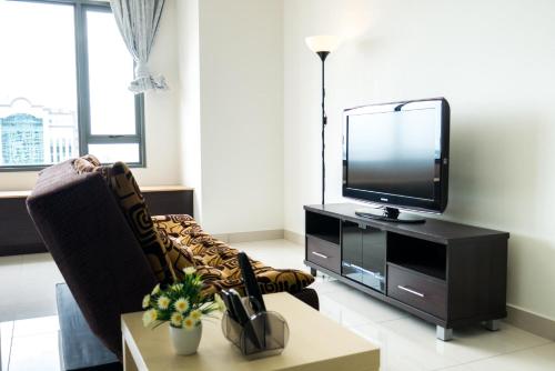 a living room with a tv and a chair at DaMen Homestay @SubangHomeStay in Subang Jaya