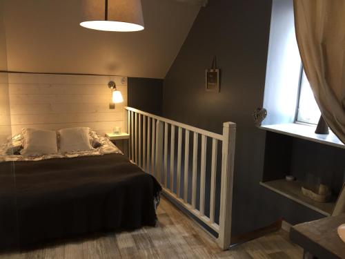 a bedroom with a bed and a white crib at Le Gite du Petit Lavoir in Bèze