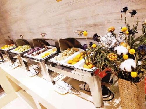 uma linha de buffet com várias bandejas de comida em Lavande Hotel Taixing Jiangping Road em Taixing