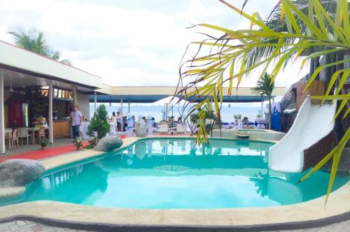 a pool in a resort with a palm tree at Estrella Del Mar in Toledo City