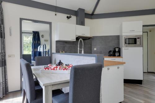 a kitchen and dining room with a table and chairs at Bungalowpark Het Verscholen Dorp in Harderwijk