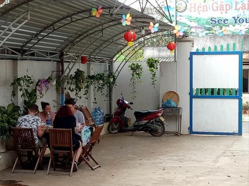 un grupo de personas sentadas en una mesa en un garaje en Binh An Backpacker Guesthouse, en Ho Coc