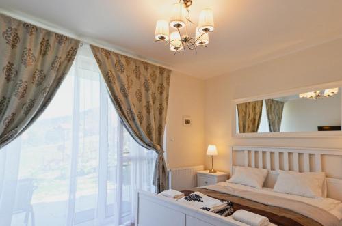 um quarto com uma cama e uma grande janela em Sun&Sport Apartament PARZENICA w super lokalizacji niedaleko wyciagu em Szczyrk