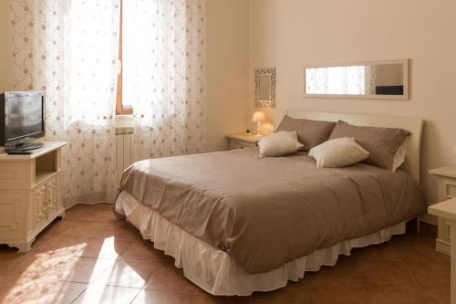 a bedroom with a large bed and a television at Orione in Borghetto