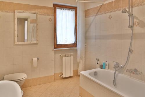 a bathroom with a tub and a toilet and a shower at Orione in Borghetto