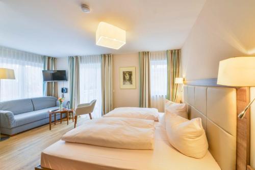 ein Hotelzimmer mit einem Bett und einem Sofa in der Unterkunft Der Kramerhof in Dießen am Ammersee
