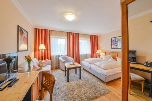 a hotel room with a bed and a living room at Der Kramerhof in Dießen am Ammersee