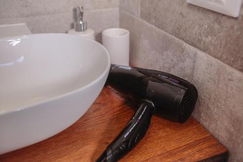 a hair dryer sitting next to a bathroom sink at San Pierino Charming Rooms in Lucca
