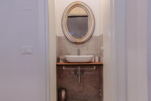 a bathroom with a sink and a mirror on the wall at San Pierino Charming Rooms in Lucca