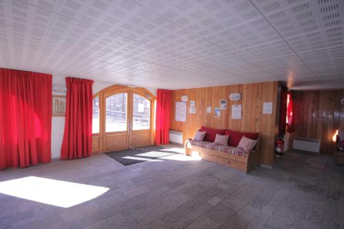 ヴァールにあるL'Ecrin des Neigesのリビングルーム(赤いカーテン、ソファ付)