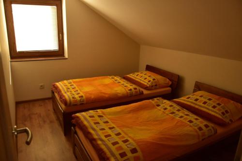 3 camas en una habitación con ventana en Apartmán-Hovorany en Hovorany