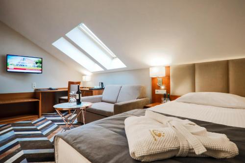 a hotel room with a bed and a chair at Hotel Belweder in Ustroń