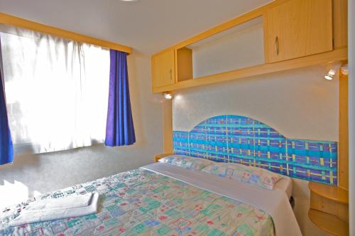 una camera con letto e testiera blu di Arena Medulin Mobile Homes a Medulin