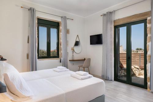 a bedroom with two beds and a large window at Trialonia Luxury Villa in Kissamos