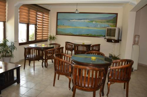 a dining room with tables and chairs and a tv at Xanemos Port Xanemos Studios in Skiathos Town