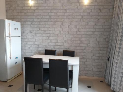 a white table with chairs and a white brick wall at Apartment Gorgiladze 66 in Batumi