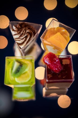 a group of different colored desserts in glass containers at Hotel Belweder in Ustroń