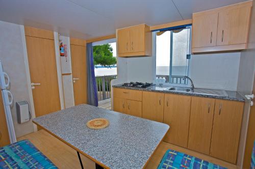 a kitchen with a table and a counter top at Arena Medulin Mobile Homes in Medulin