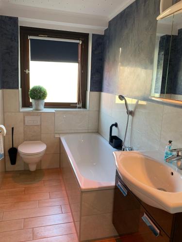 a bathroom with a tub and a sink and a toilet at 29 Haster Straße in Bad Nenndorf