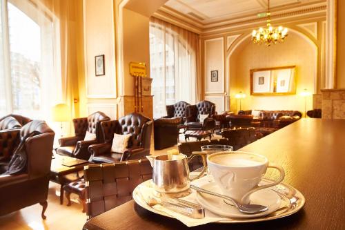 a room with a table with a cup of coffee on it at Grand Hotel Continental Bucuresti in Bucharest