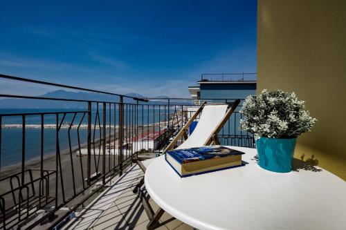 a book on a table on a balcony with the beach at On the beach Sea-view&Kitchen In Room in Salerno