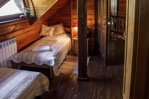 a bedroom with two beds in a log cabin at Maciejówka Borki 33 in Borki