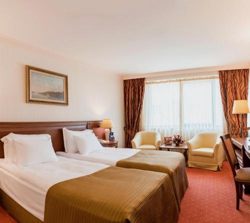 ein Hotelzimmer mit 2 Betten und einem Schreibtisch in der Unterkunft Crystal Palace Boutique Hotel in Sofia