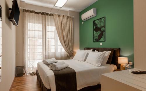 sypialnia z łóżkiem z zielonymi ścianami i oknem w obiekcie Monastiraki Urban Apartments w Atenach