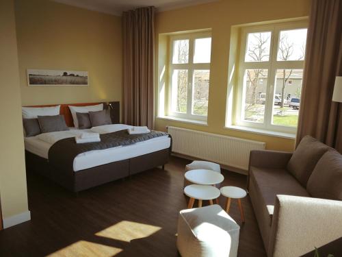 ein Hotelzimmer mit einem Bett und einem Sofa in der Unterkunft Gut Gnewikow in Gnewikow