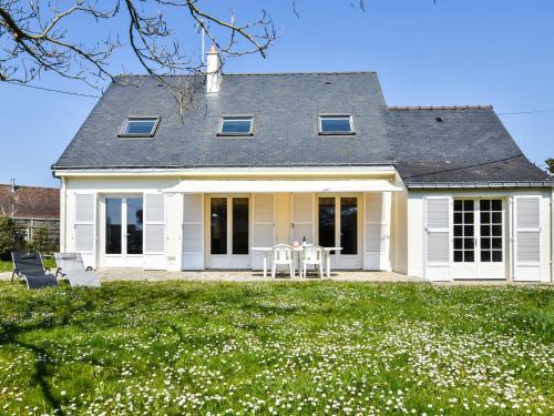 a white house with a table and chairs in a yard at Peaceful holiday home near the beach in Pénestin