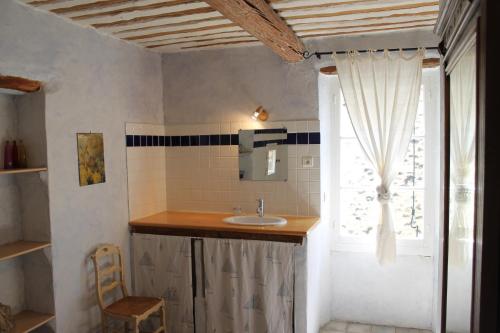 a bathroom with a sink and a window at L'autre côté du lavoir in Saint-Didier