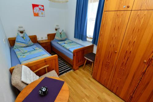 a small room with two beds and a table at Haus Brandner in Tröpolach