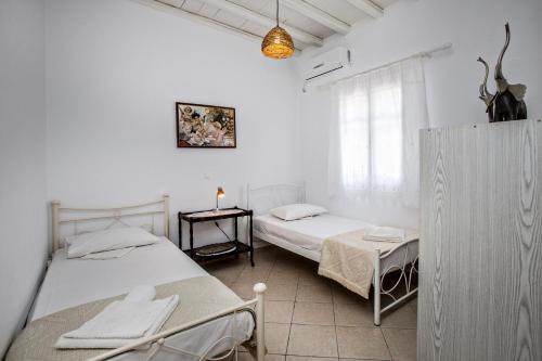 a bedroom with two beds and a window at Andrea's Tinos House in Agios Sostis
