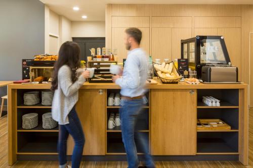 a man and a woman standing at a counter at Aparthotel Adagio access Montpellier Centre in Montpellier