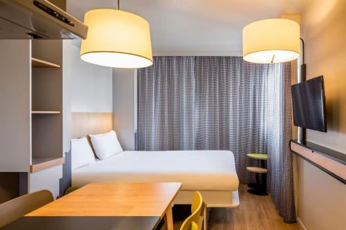 a hotel room with a bed and a table at Aparthotel Adagio access Montpellier Centre in Montpellier