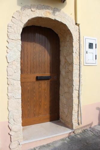 eine Holztür in einem steinernen Torbogen in der Unterkunft Appartamento Gemma in Tropea