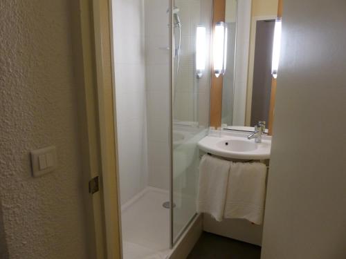 een badkamer met een douche, een wastafel en een douche bij ibis Périgueux Centre in Périgueux