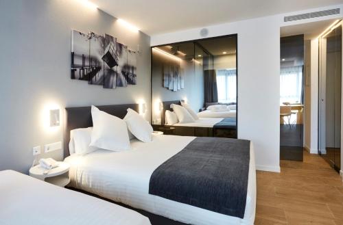 a hotel room with two beds and a mirror at Sercotel Valencia Alameda 41 in Valencia